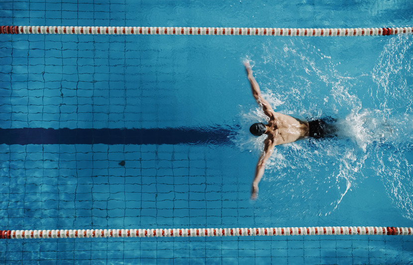 Swimmer doing butterfly stroke in an Olympic pool