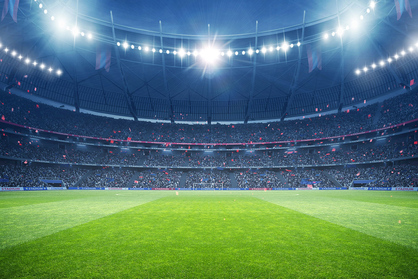 A sports stadium under lights will a full house of spectators