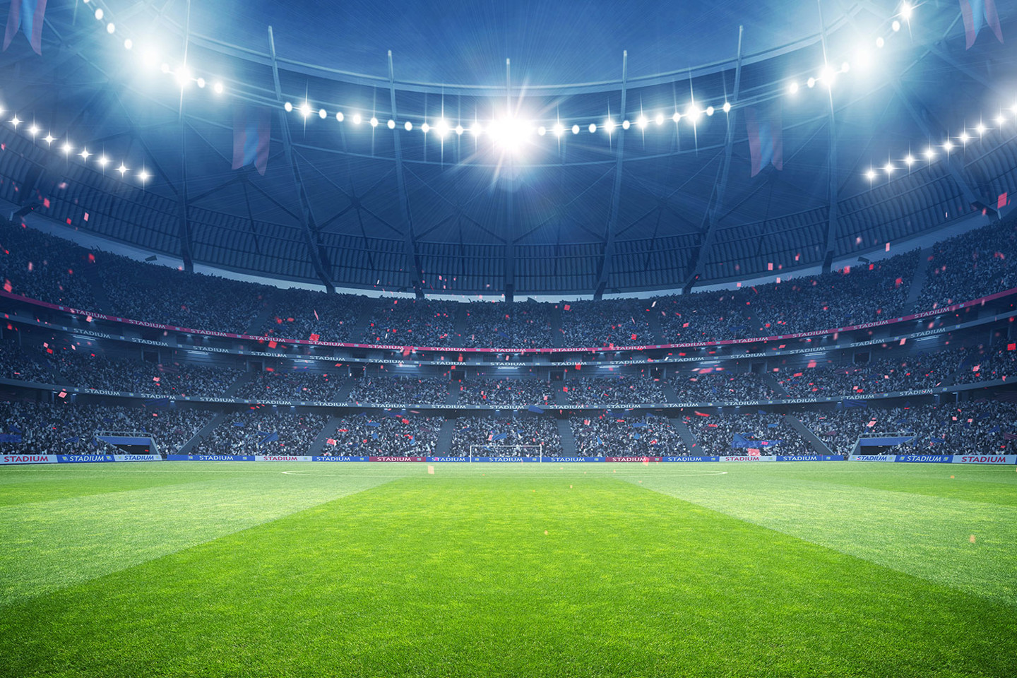 A sports stadium under lights will a full house of spectators