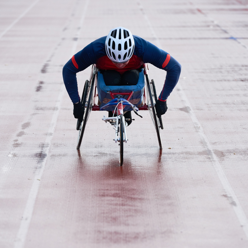 Physically impaired male athlete cycling towards finish line 