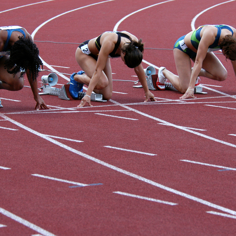 Female athletes prepare to sprint on a track race 